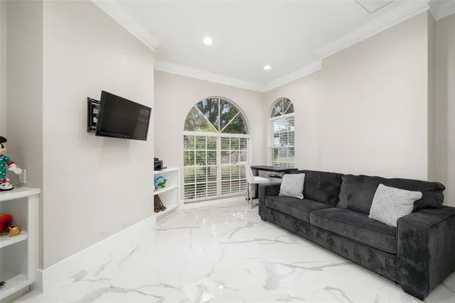 a living room with furniture a flat screen tv and a floor to ceiling window