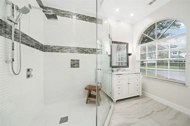 a bathroom with a granite countertop sink a mirror and shower