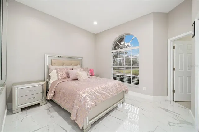 a bedroom with a bed a mirror and a window