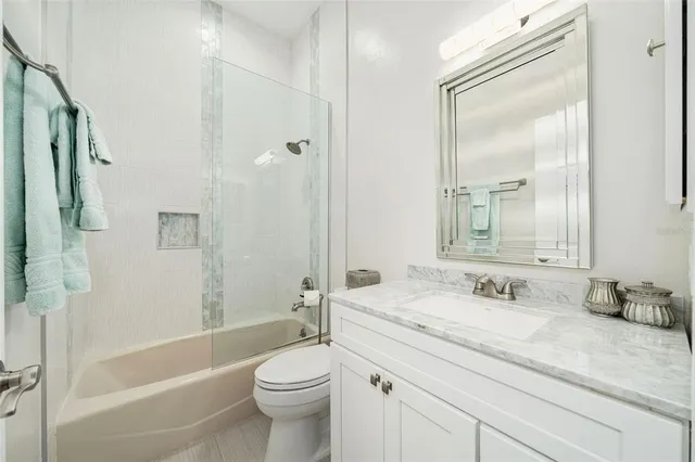 a bathroom with a granite countertop sink a toilet and shower