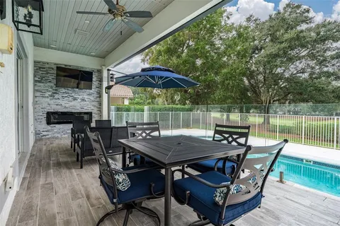a patio with wooden floor a yard a table and chairs