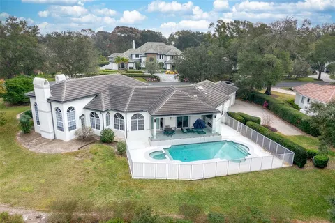 an aerial view of a house with swimming pool and a yard