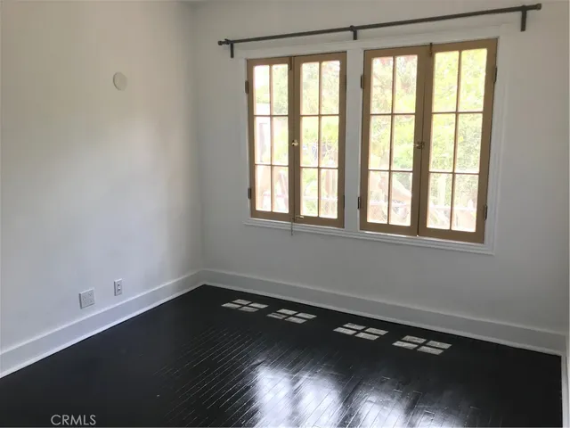 a view of a room with wooden floor and a window
