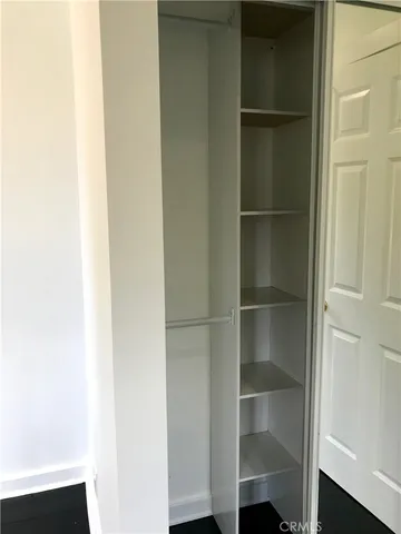 a room with walk in closet with wooden floor