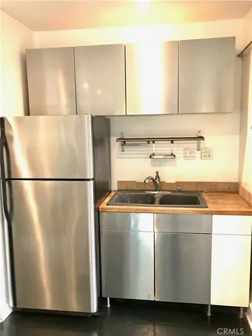 a view of a refrigerator a sink and an oven