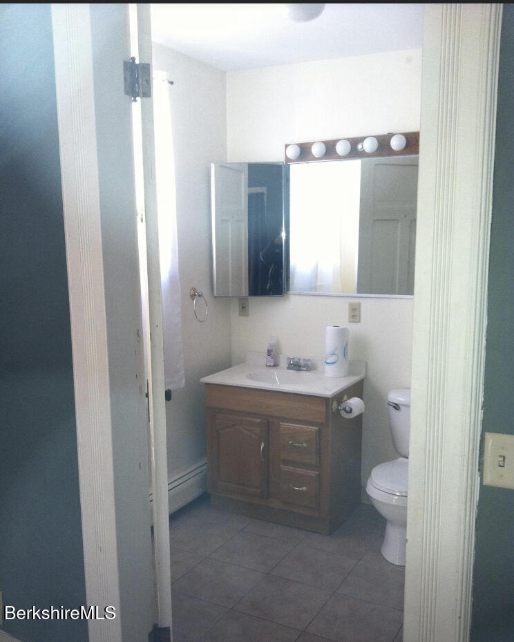 144 Church Street, Unit 2 North Adams, MA 01247 - Photo 5 of 8 a bathroom with a granite countertop sink toilet and shower