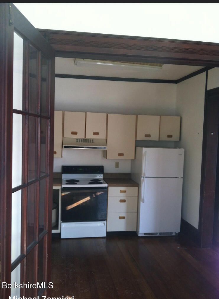 144 Church Street, Unit 2 North Adams, MA 01247 - Photo 6 of 8 a kitchen with a refrigerator stove and white cabinets