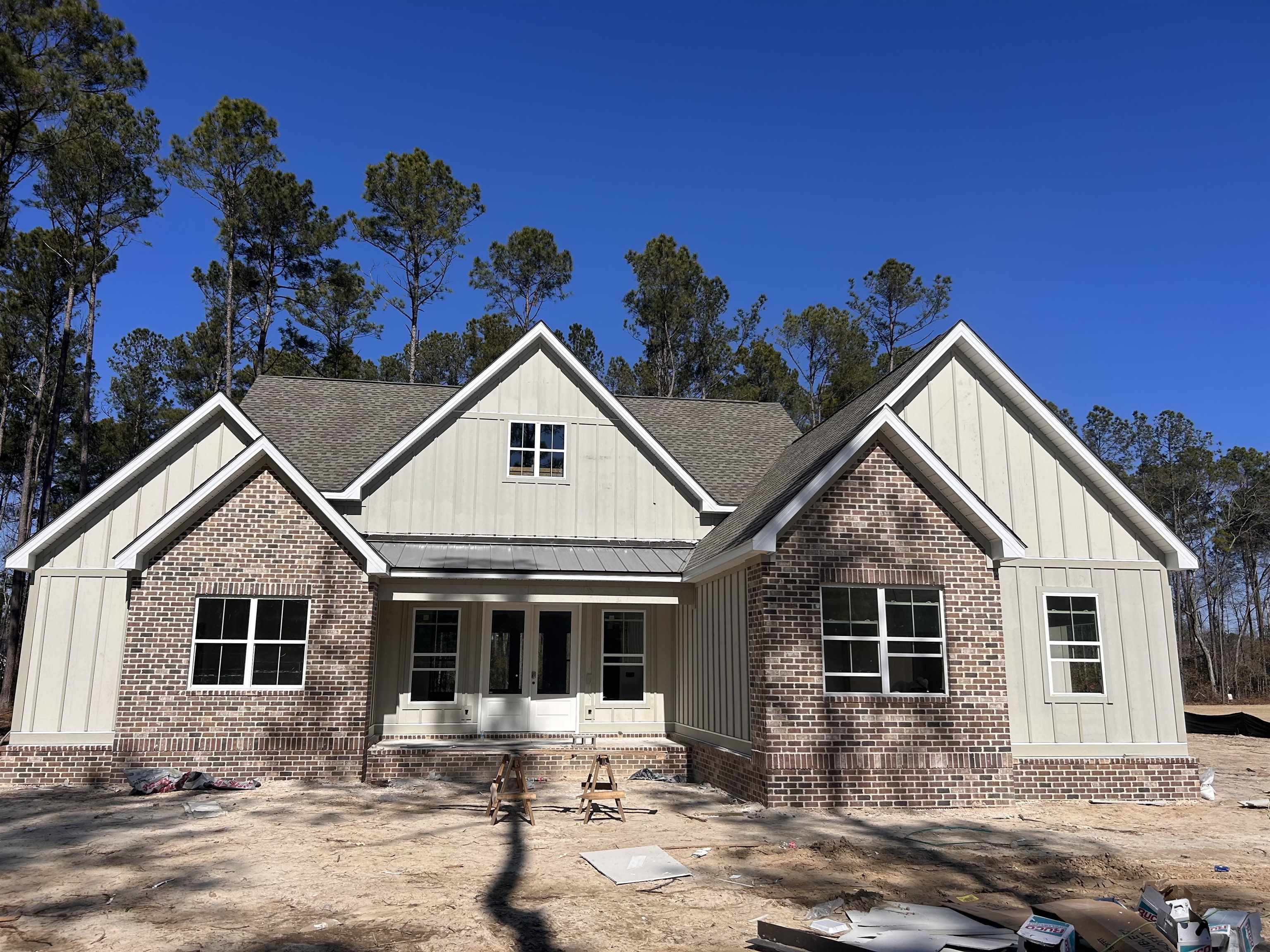 Rear view of house with roof with shingles and view of scattered trees