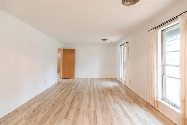 a view of empty room with wooden floor and fireplace