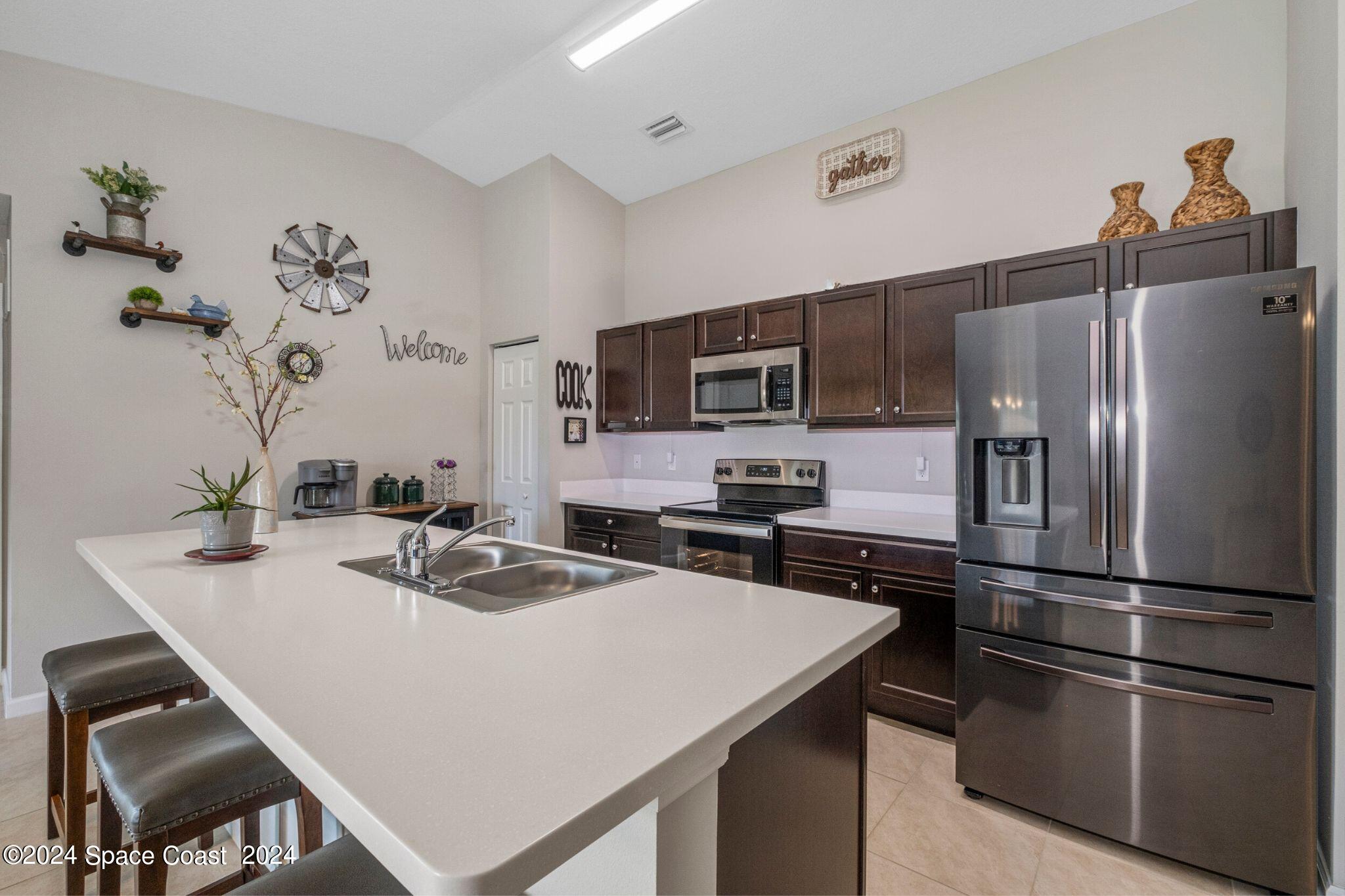 1011 Grapefruit Road Southeast Palm Bay, FL 32909 - Photo 10 of 42 a kitchen with kitchen island a counter top space appliances and cabinets