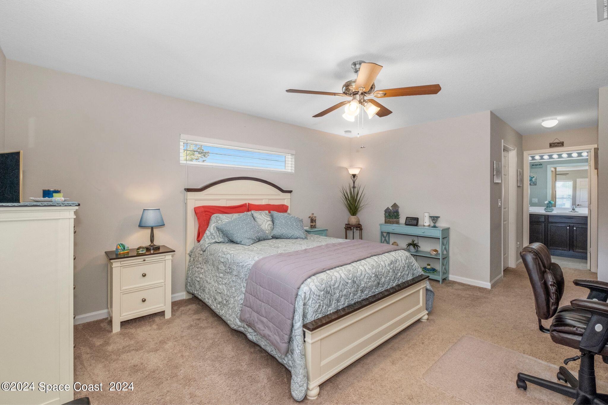 1011 Grapefruit Road Southeast Palm Bay, FL 32909 - Photo 13 of 42 a bedroom with a bed and a chandelier
