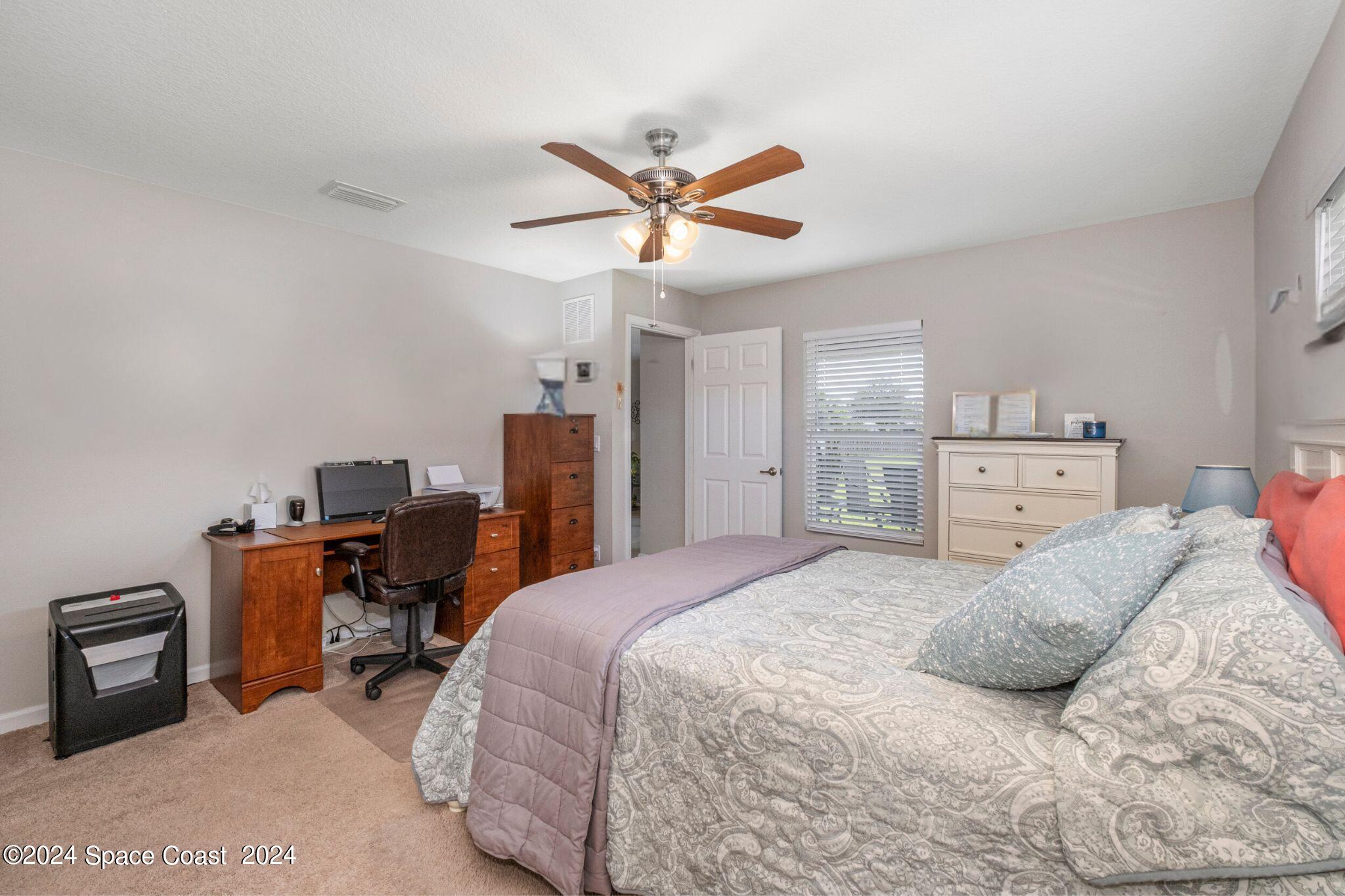 1011 Grapefruit Road Southeast Palm Bay, FL 32909 - Photo 14 of 42 a bedroom with a bed and a chandelier