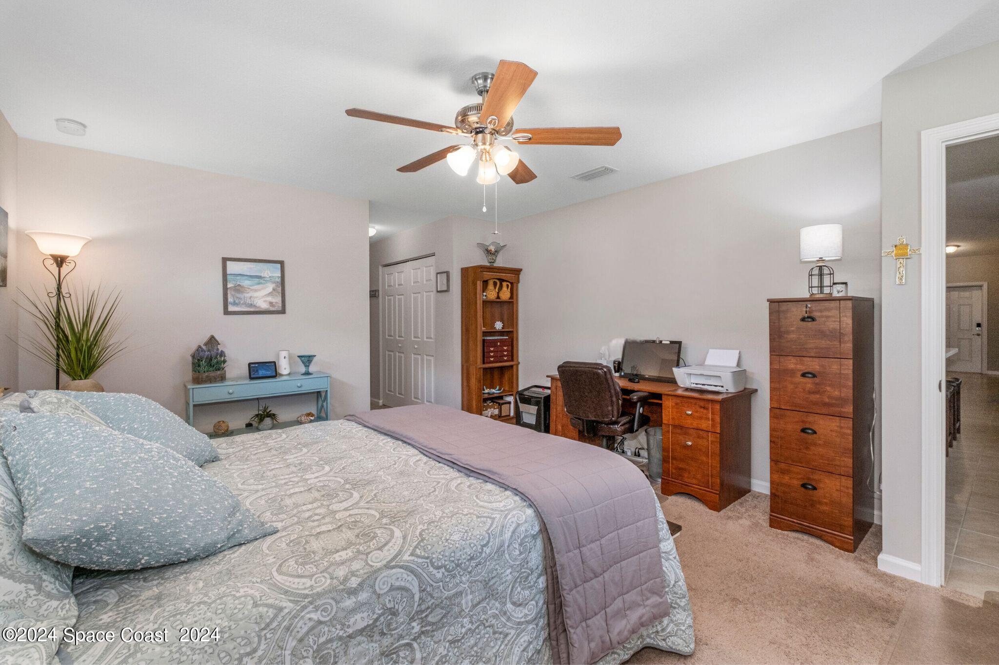 1011 Grapefruit Road Southeast Palm Bay, FL 32909 - Photo 16 of 42 a bedroom with a bed and a chandelier