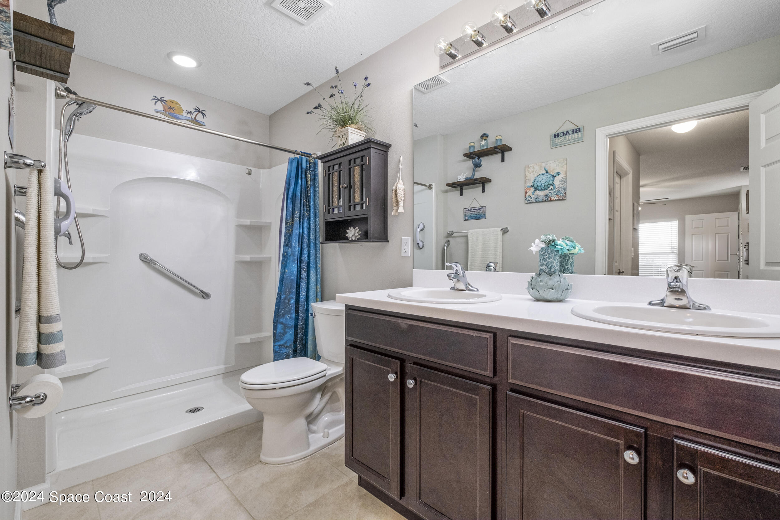 1011 Grapefruit Road Southeast Palm Bay, FL 32909 - Photo 17 of 42 a bathroom with a double vanity sink toilet and shower