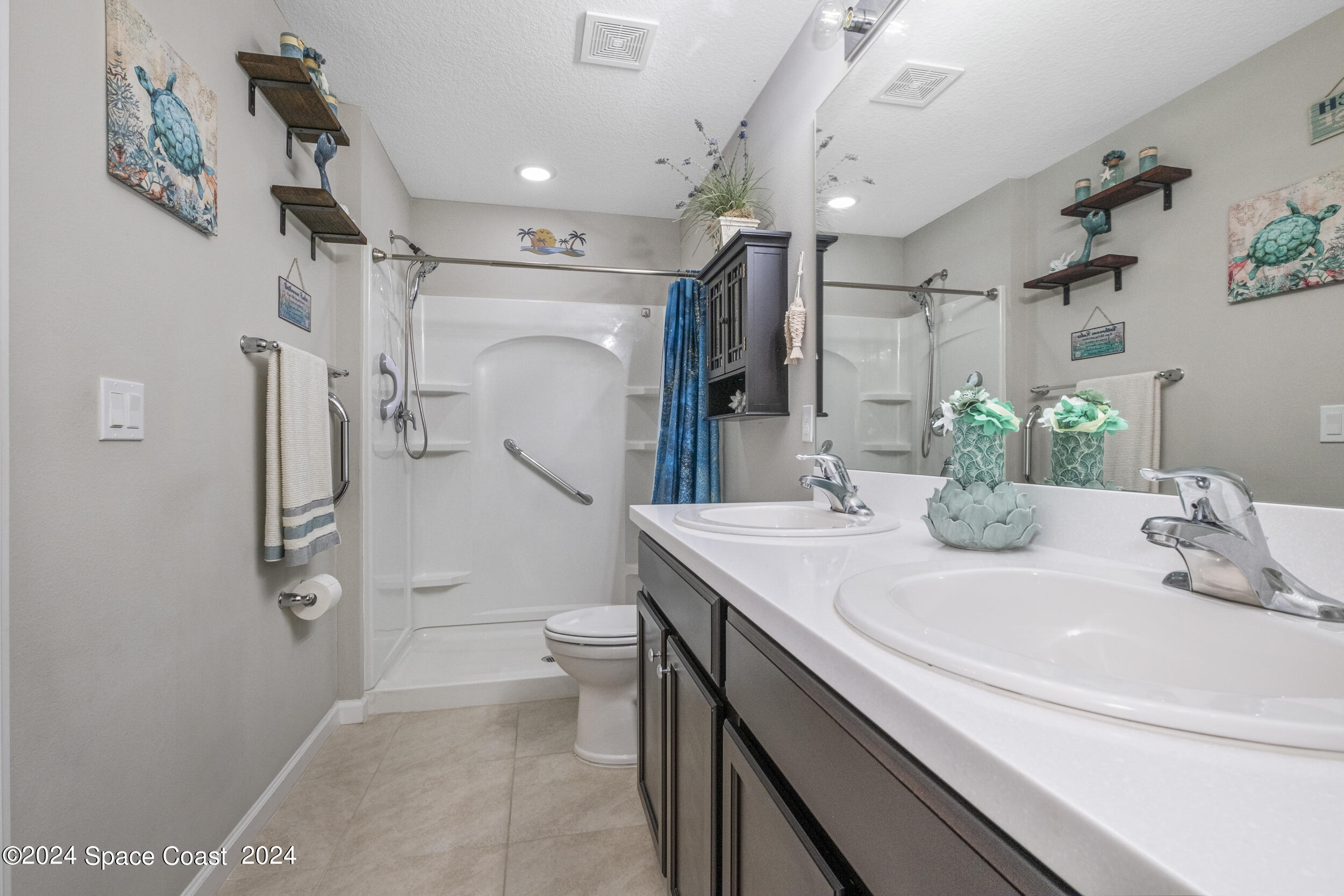 1011 Grapefruit Road Southeast Palm Bay, FL 32909 - Photo 18 of 42 a bathroom with a sink a toilet a mirror and shower