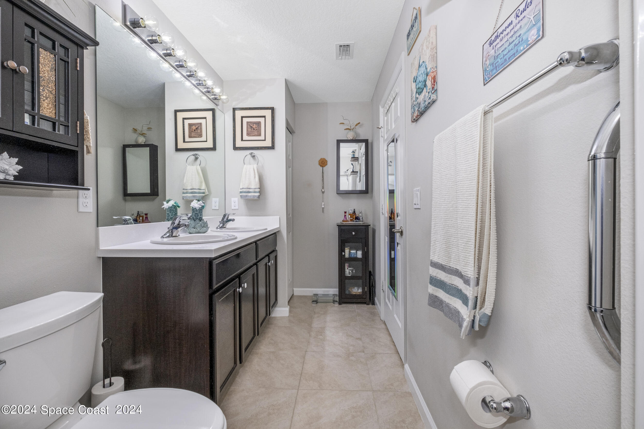 1011 Grapefruit Road Southeast Palm Bay, FL 32909 - Photo 19 of 42 a bathroom with a double vanity sink toilet and shower