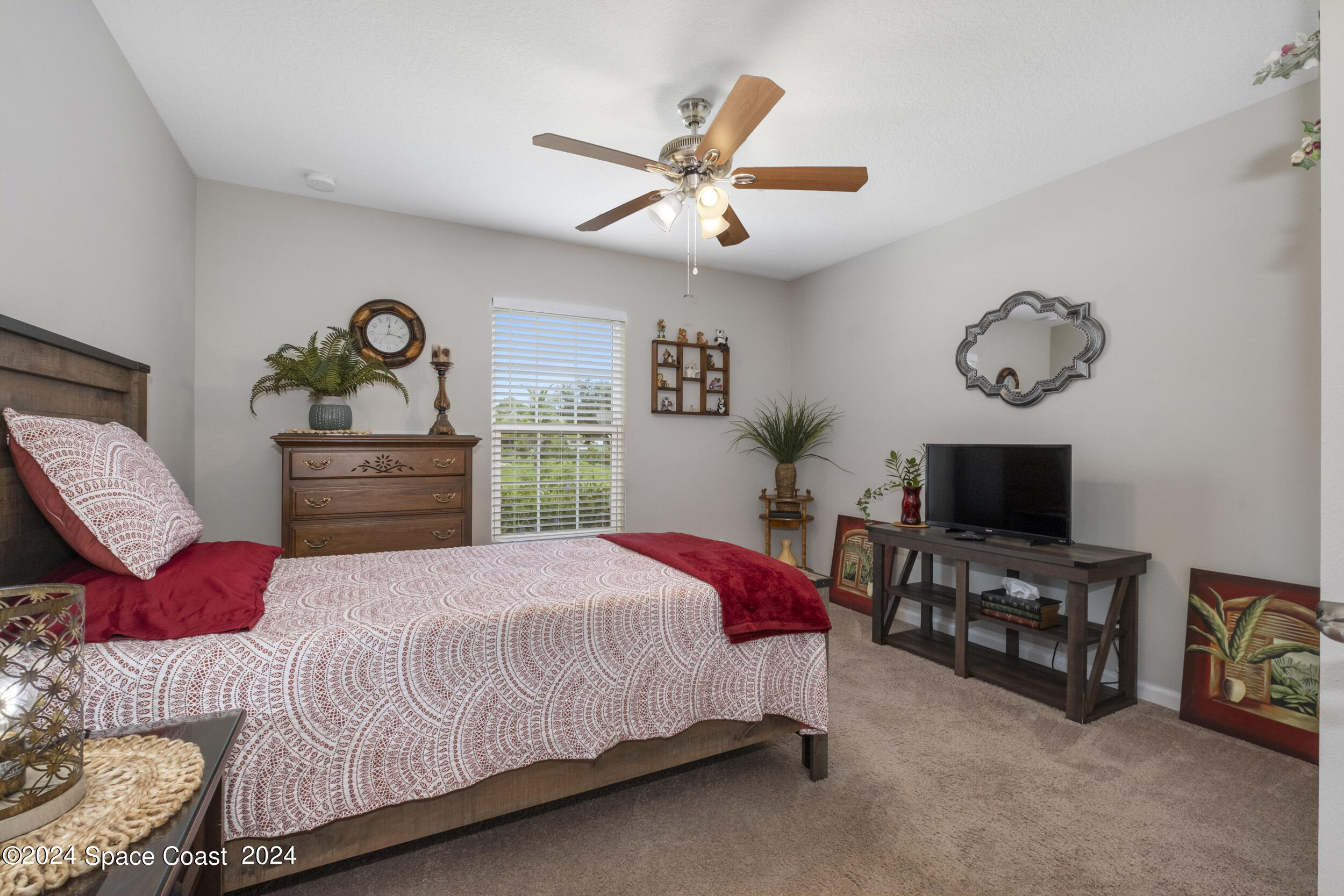 1011 Grapefruit Road Southeast Palm Bay, FL 32909 - Photo 25 of 42 a bedroom with a bed and a chandelier