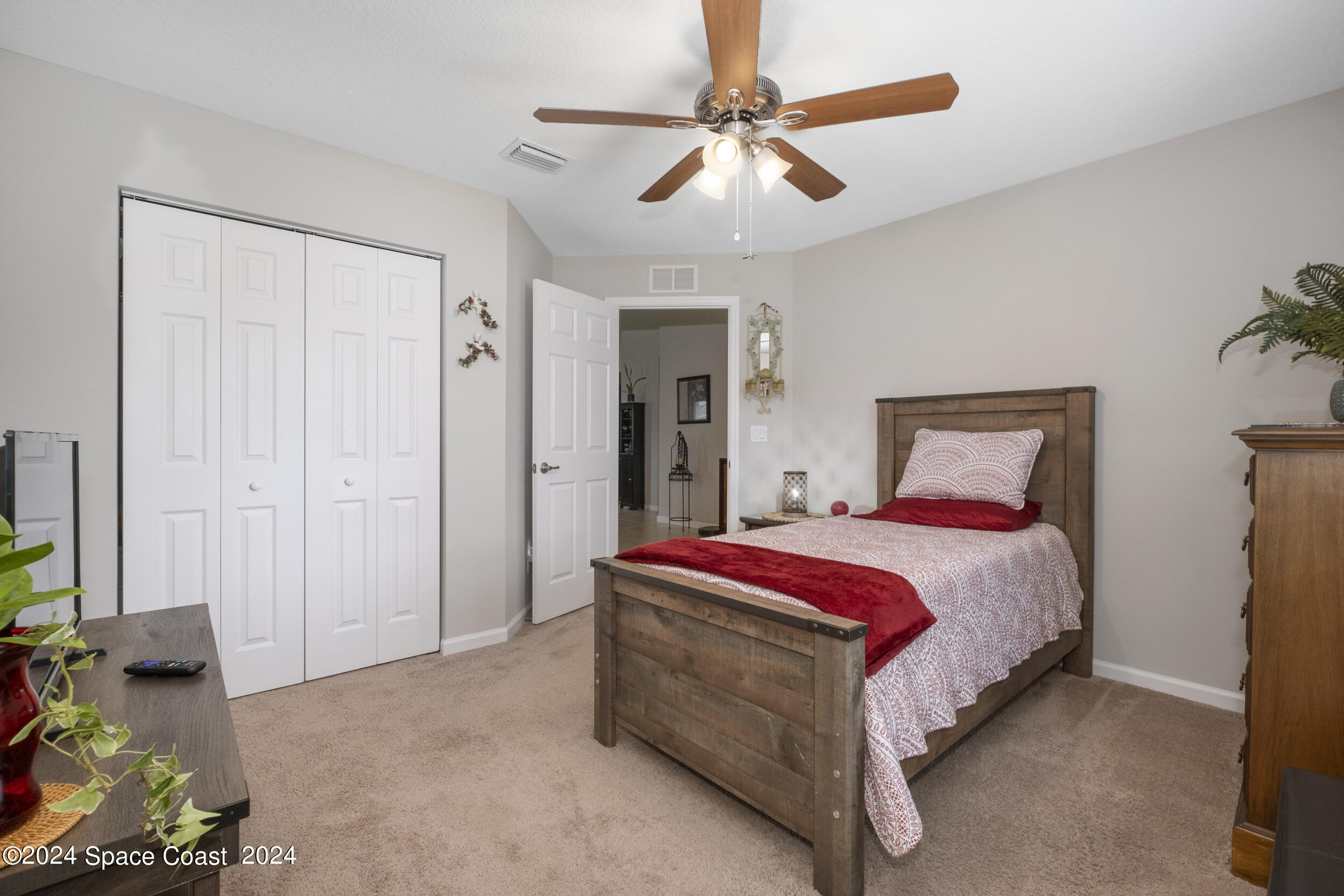 1011 Grapefruit Road Southeast Palm Bay, FL 32909 - Photo 27 of 42 a spacious bedroom with a bed and a chandelier