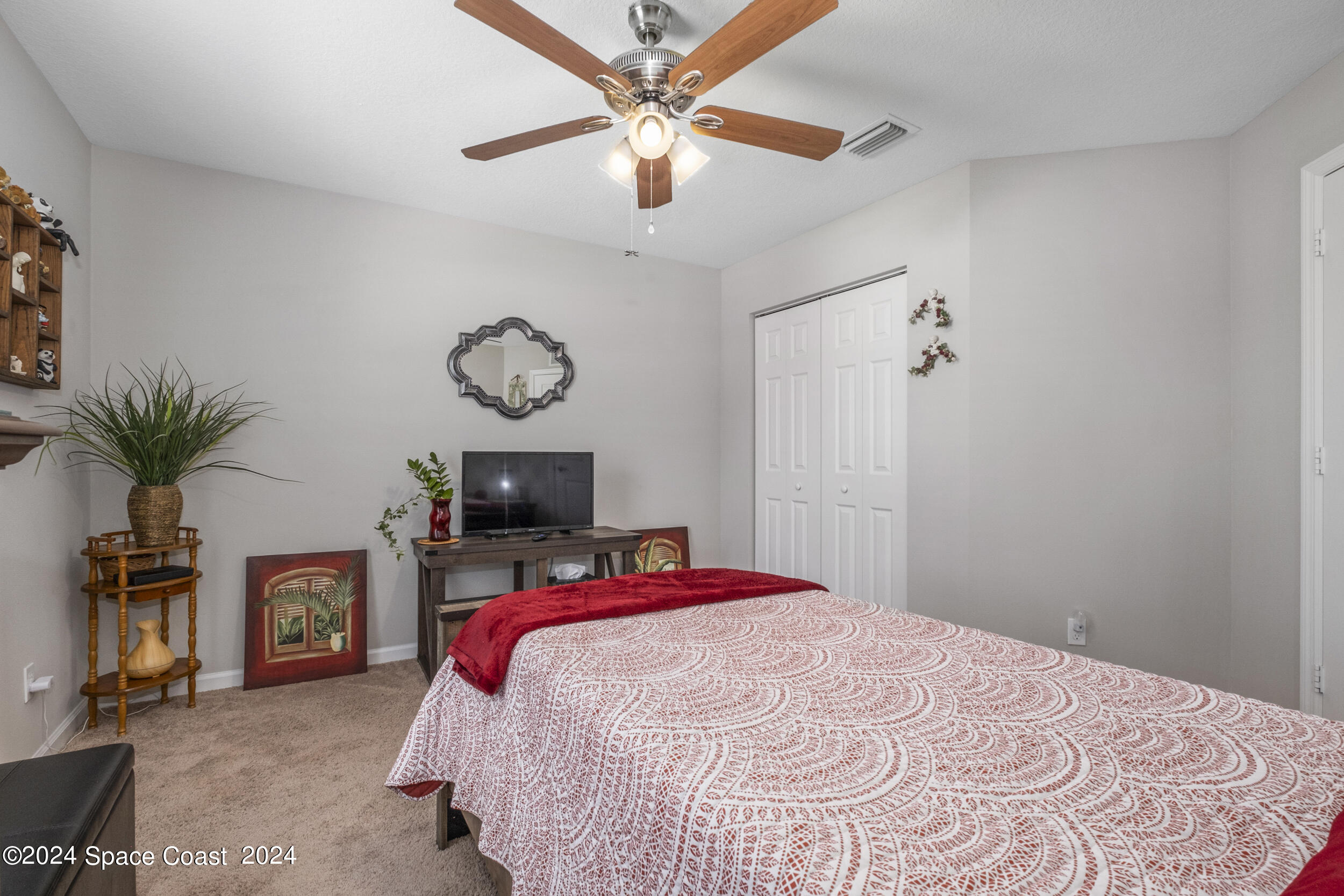 1011 Grapefruit Road Southeast Palm Bay, FL 32909 - Photo 28 of 42 a bedroom with a bed and a chandelier