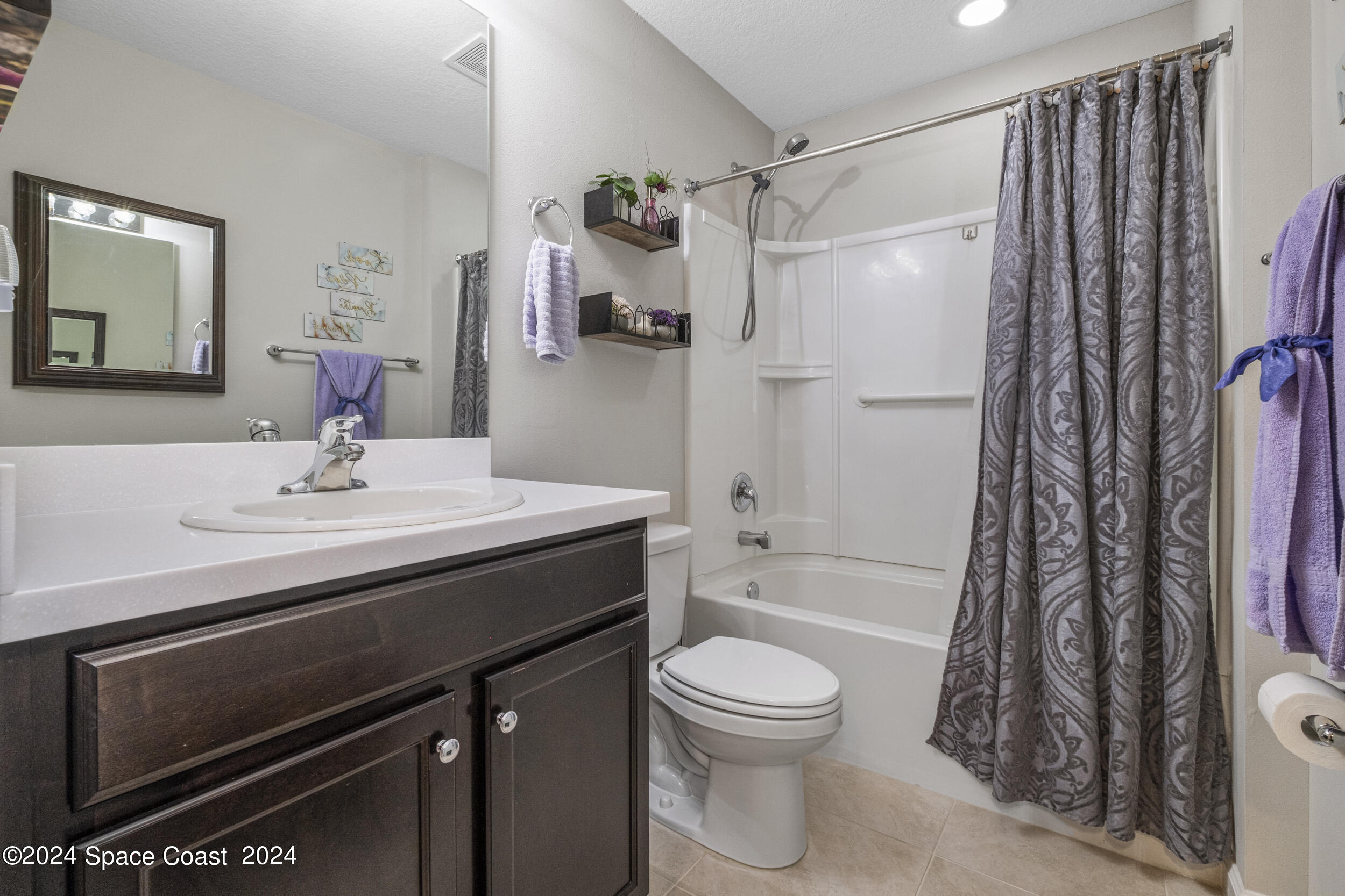 1011 Grapefruit Road Southeast Palm Bay, FL 32909 - Photo 29 of 42 a bathroom with a sink a toilet a mirror and shower