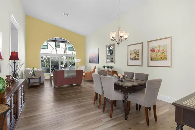 a view of a dining room with furniture a chandelier and wooden floor
