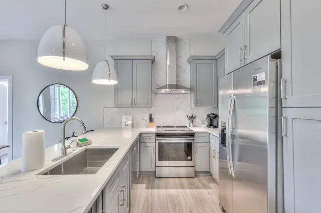 a kitchen with kitchen island granite countertop a sink a counter space appliances and cabinets