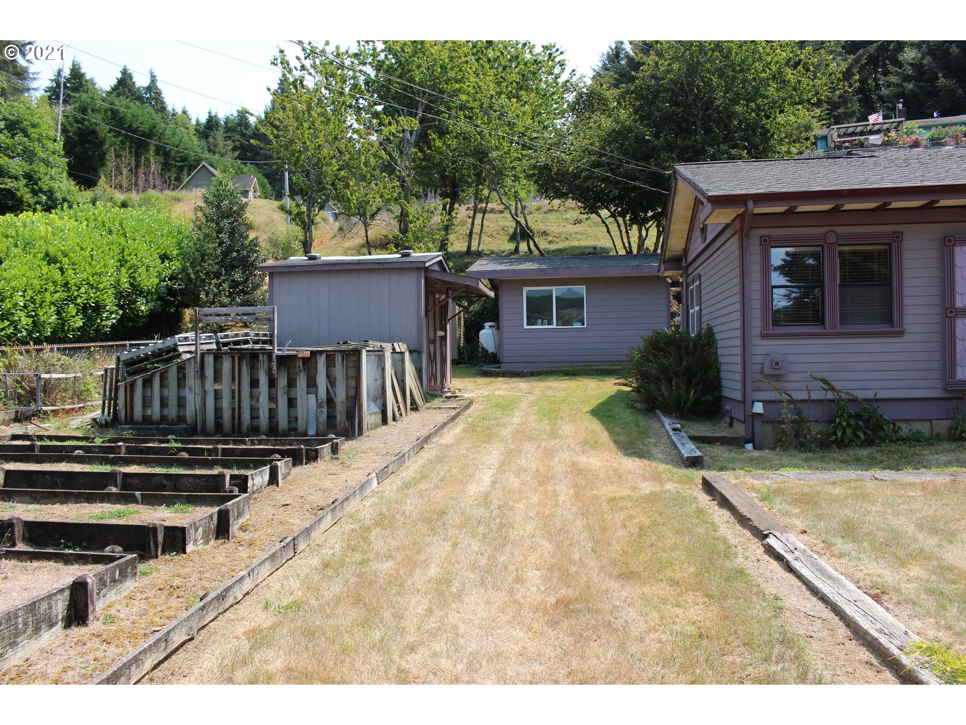 66069 North Bay Road North Bend, OR 97459 - Photo 7 of 32 a view of a house with wooden deck and a yard
