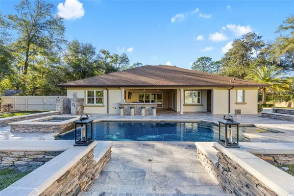 a view of a house with swimming pool and sitting area