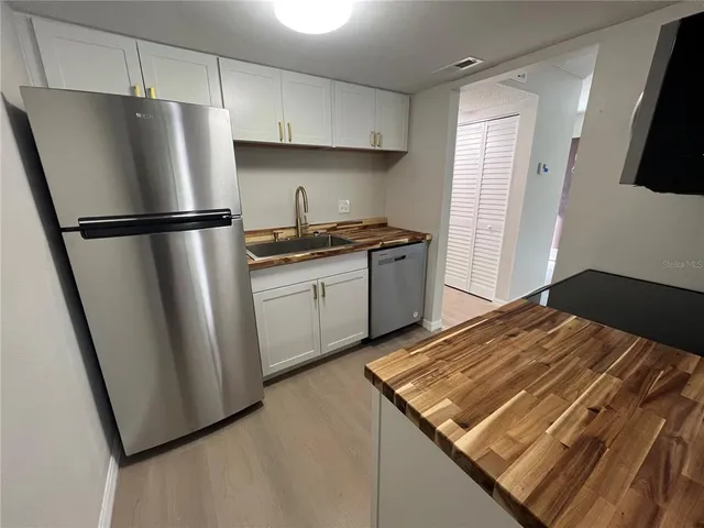 a kitchen with stainless steel appliances granite countertop a refrigerator stove a sink and dishwasher