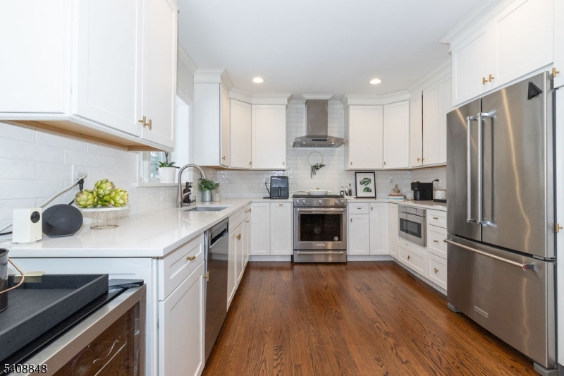 717 Fairmount Avenue Chatham, NJ 07928 - Photo 11 of 35 a kitchen with kitchen island white cabinets stainless steel appliances and wooden floor