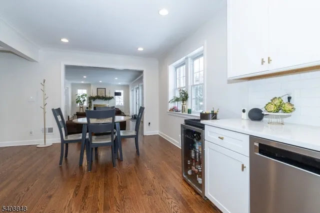 a kitchen with a dining table chairs wooden floor and appliances