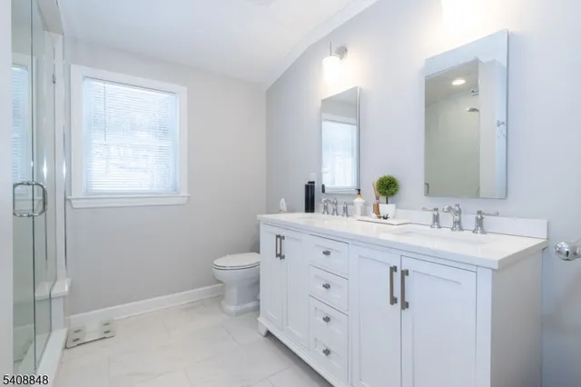 a bathroom with a double vanity sink a toilet and a mirror