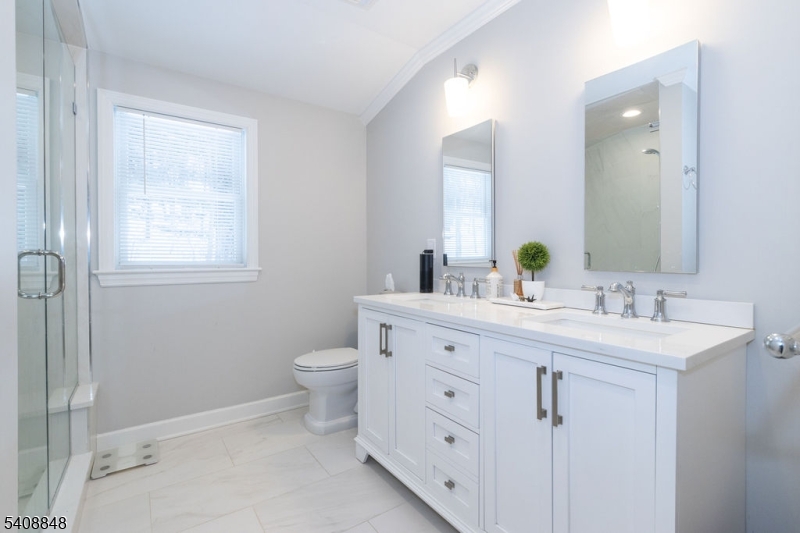 717 Fairmount Avenue Chatham, NJ 07928 - Photo 27 of 35 a bathroom with a double vanity sink a toilet and a mirror