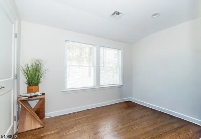 an empty room with wooden floor and a window