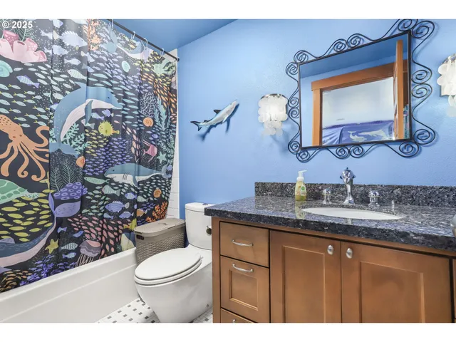 a bathroom with a granite countertop toilet sink and mirror