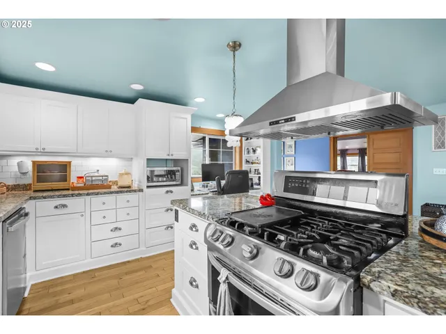 a kitchen with a stove a sink and cabinets