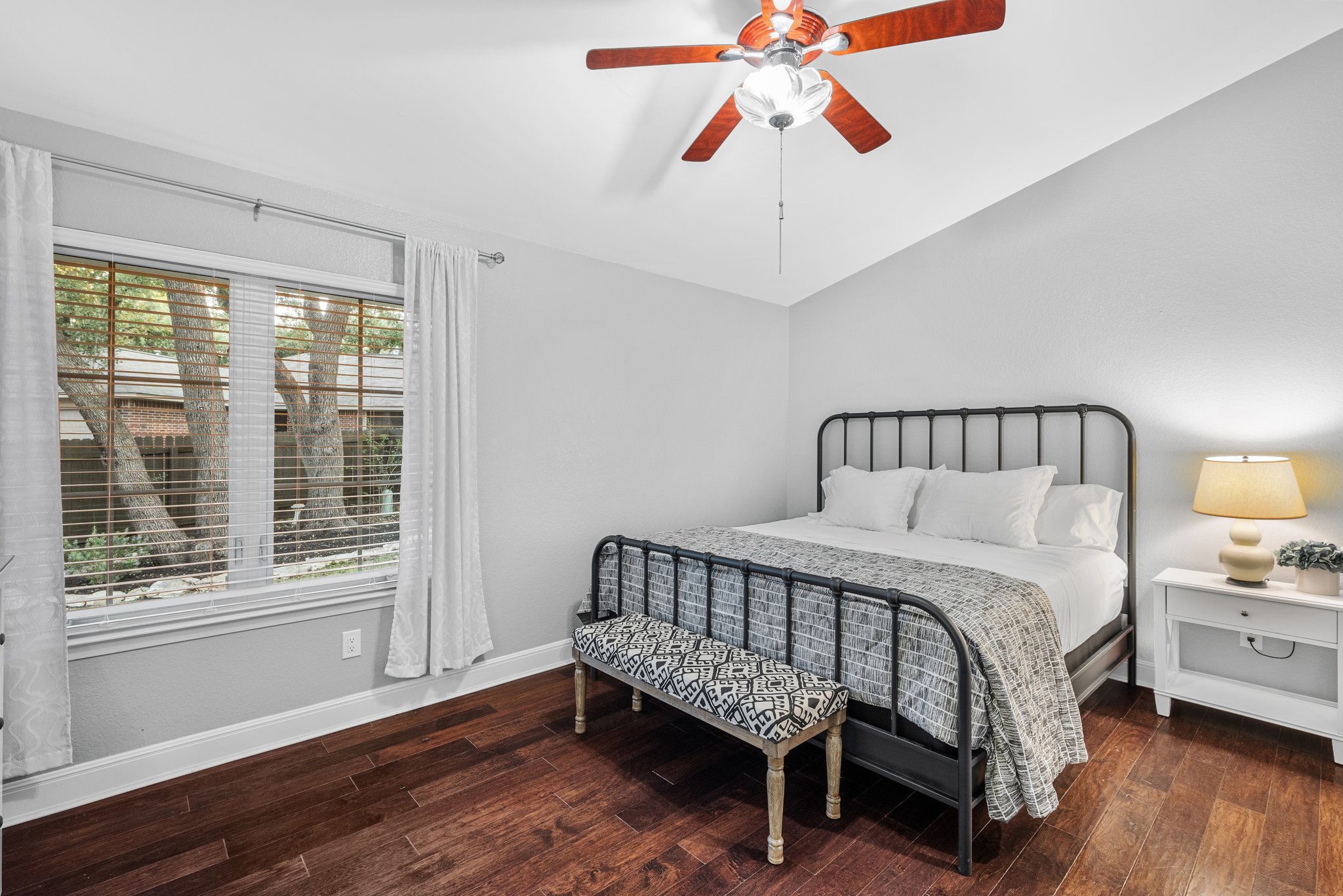7601 Dallas Drive Austin, TX 78729 - Photo 11 of 20 a bedroom with a bed and wooden floor