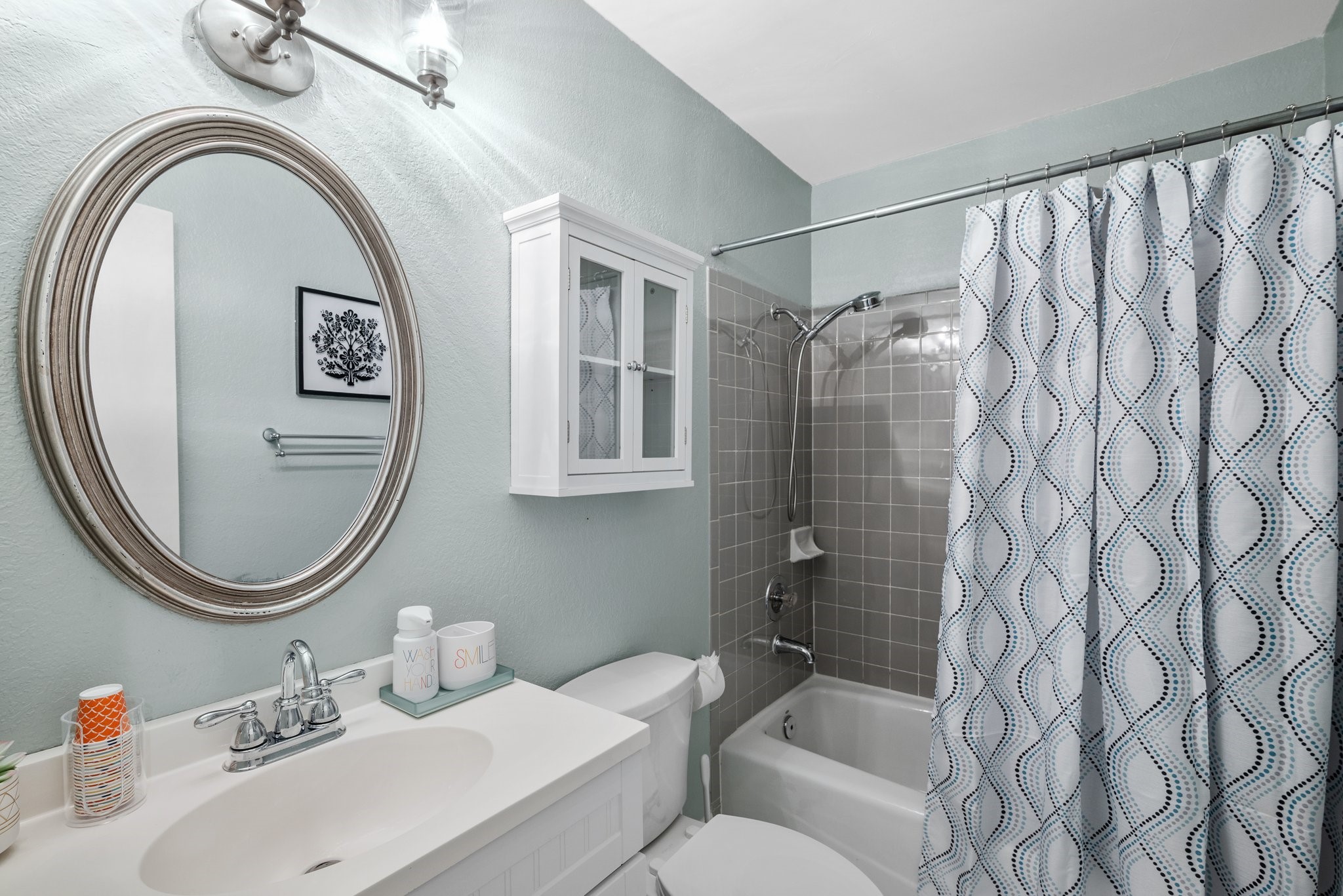 7601 Dallas Drive Austin, TX 78729 - Photo 15 of 20 a bathroom with a sink a mirror a toilet and a shower