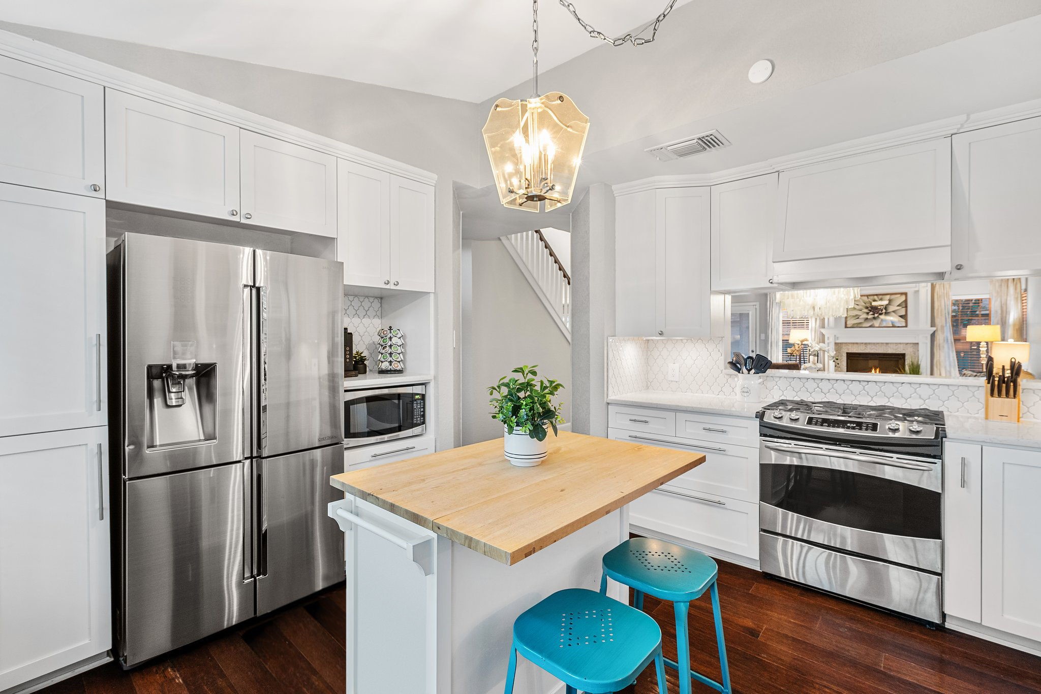 7601 Dallas Drive Austin, TX 78729 - Photo 2 of 20 a kitchen with stainless steel appliances granite countertop a refrigerator a stove a sink dishwasher a microwave oven with cabinets and wooden floor