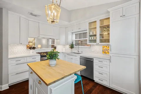 a kitchen with a center island appliances and cabinets