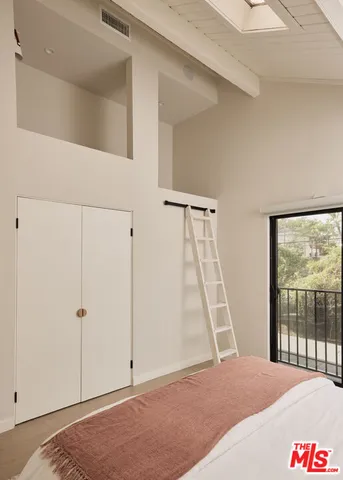 a bedroom with a bed and a large window