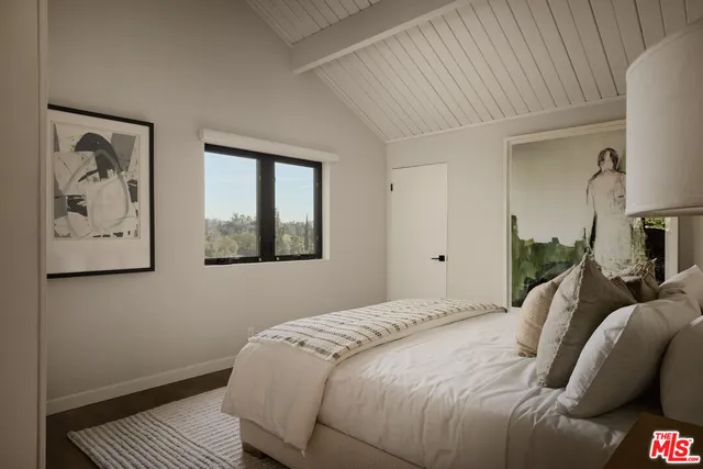 a bedroom with a bed and a painting on the wall