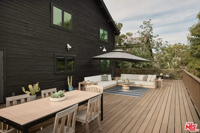 a patio with wooden floor table and chairs