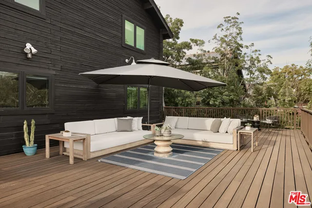 a view of a rooftop deck with couch and chairs