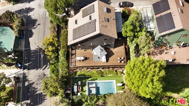 an aerial view of a house with a yard and large trees