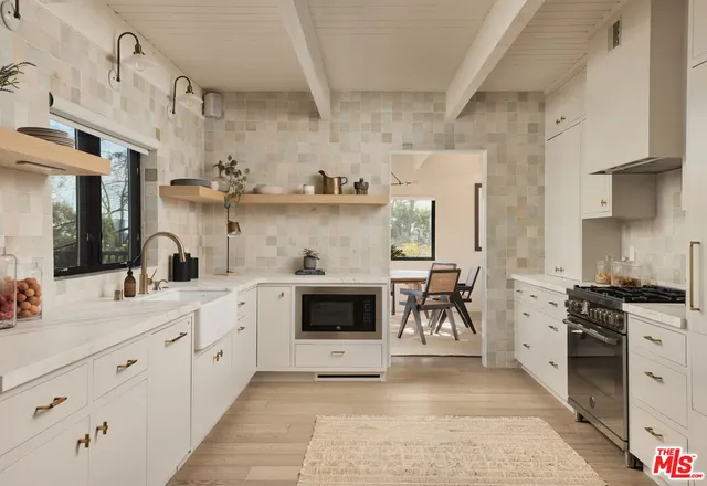 a kitchen with a white cabinets and stove top oven