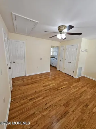 a view of a livingroom with a chandelier fan and wooden floor