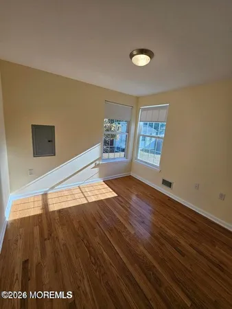 a view of a livingroom with wooden floor and window