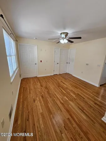 a view of room with a ceiling fan and hardwood