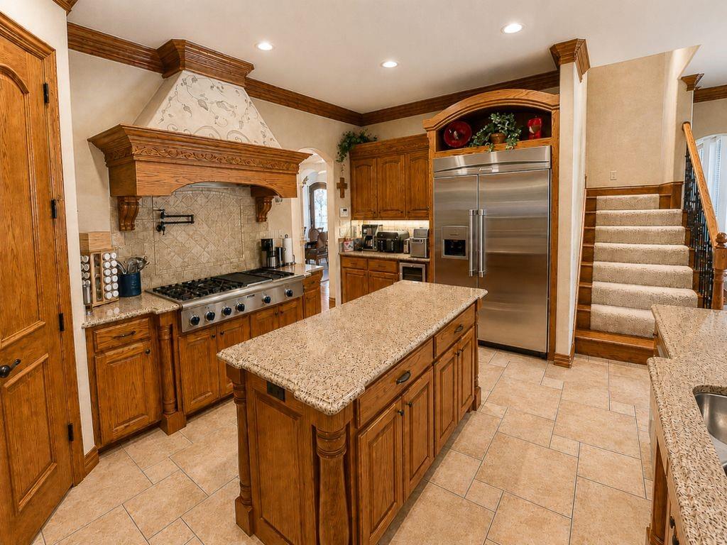 7005 Peter's Path Colleyville, TX 76034 - Photo 12 of 40 a kitchen with stainless steel appliances granite countertop a sink and a refrigerator